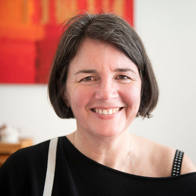 Portret van een lachende vrouw die ontspannen en zichtbaar in de camera kijkt, symbool voor zelfvertrouwen